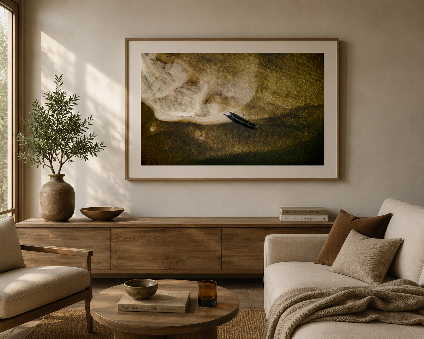 Framed aerial fine art print of a small African wooden mokoro boat on a sandy shoreline by Richard du Toit, displayed in a warm natural interior